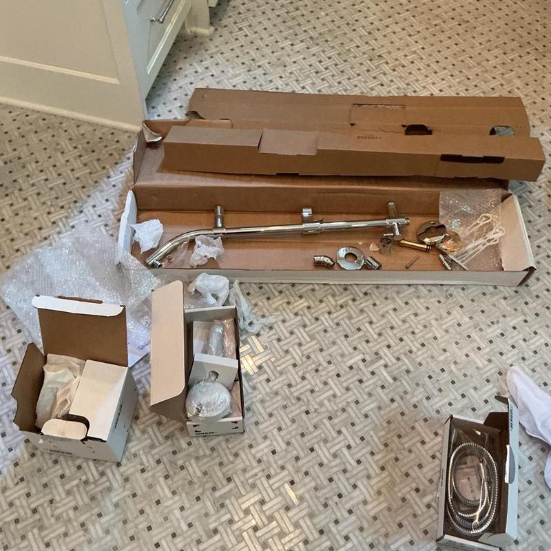 Shower trim components laid out on bathroom floor Shower trim components laid out on bathroom floor