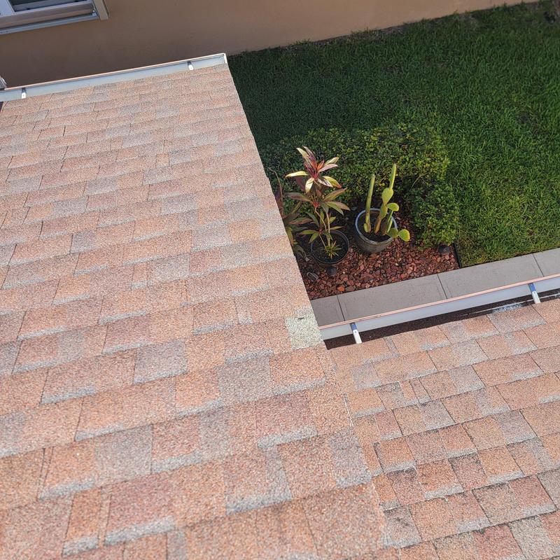 Asphalt roof shingles with visible damage patch Asphalt roof shingles with visible damage patch