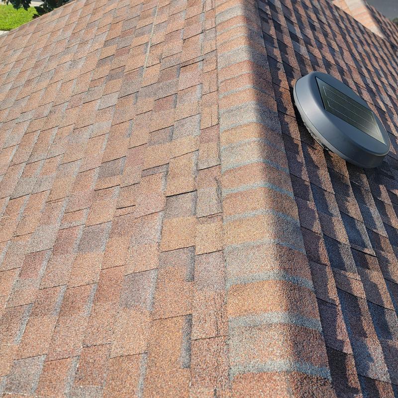 Asphalt shingle roof with visible damage near vent Asphalt shingle roof with visible damage near vent