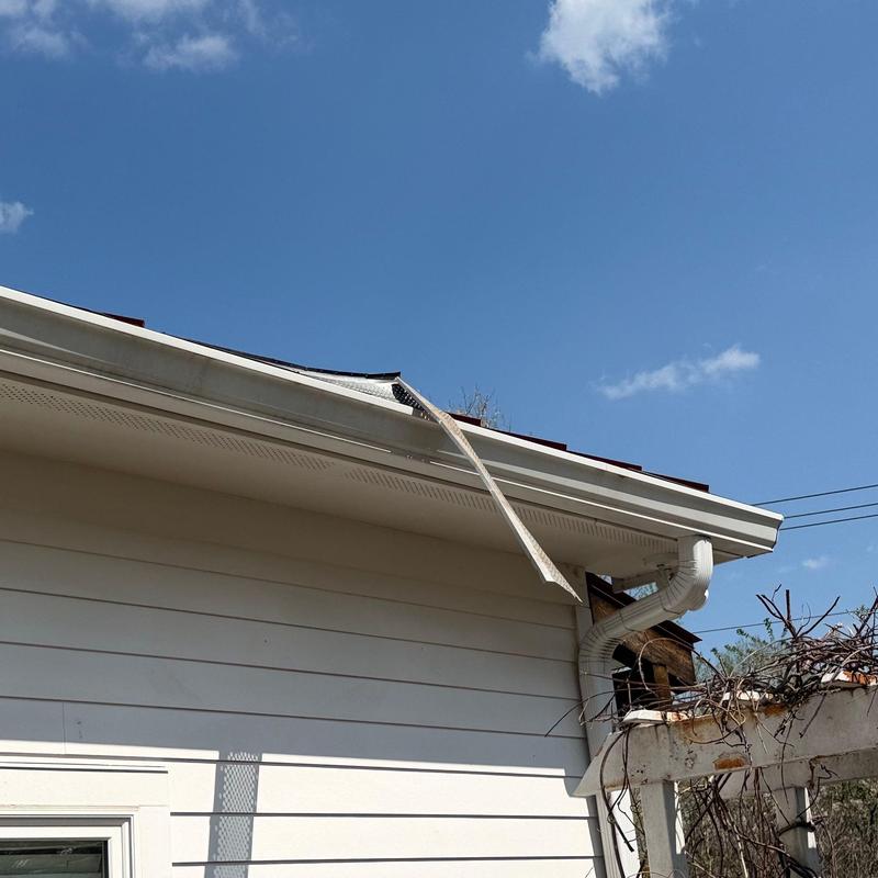Roof edge metal flashing with hail damage in Brentwood