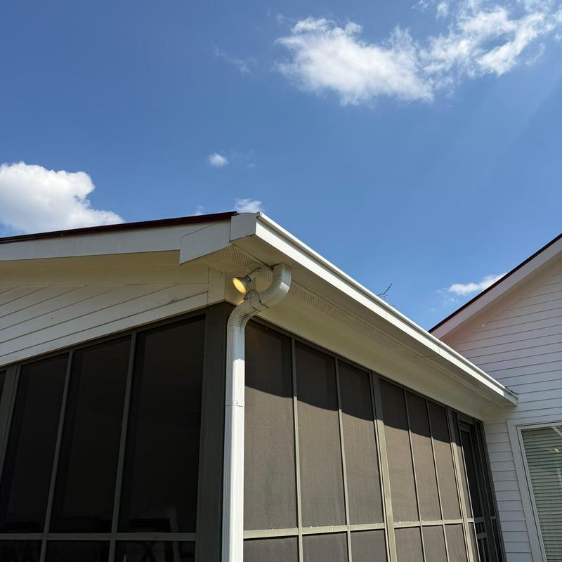 Roof gutter and downspout with clear sky background