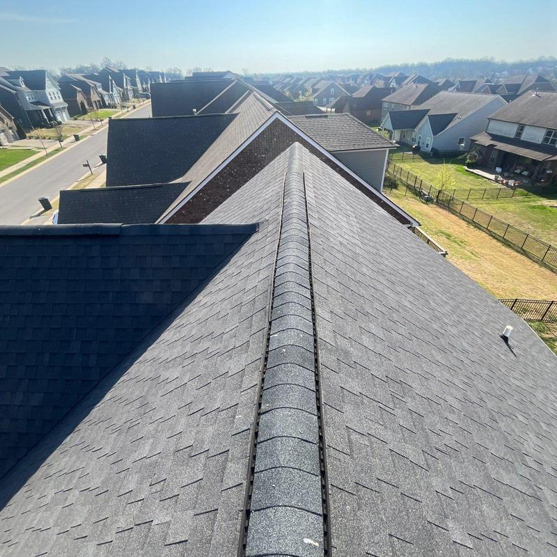 Asphalt shingle roof ridge with visible hail damage