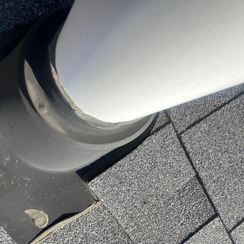 Roof pipe flashing with minor sealant wear on shingles