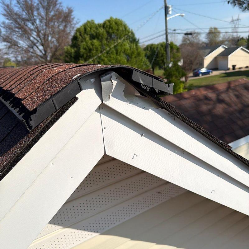 Roof ridge cap with damaged shingles and trim