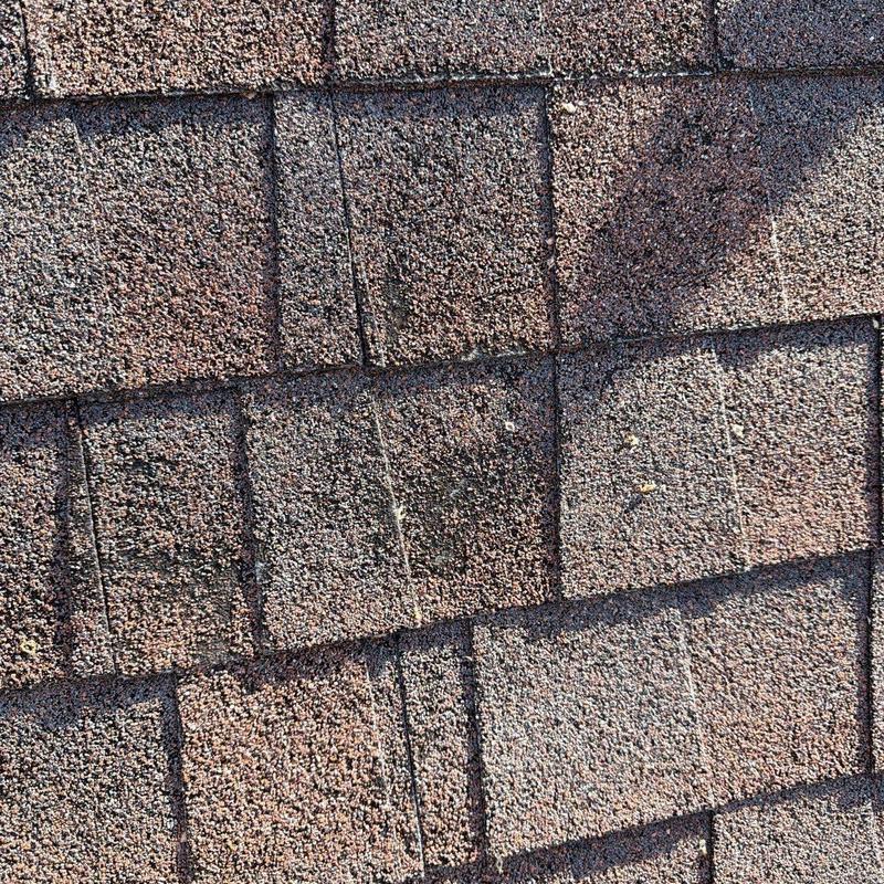 Asphalt shingles with visible hail damage on roof