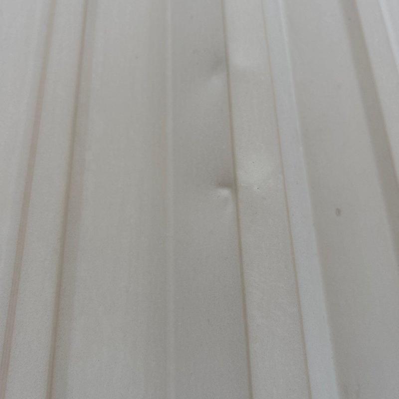 Metal roofing panels with hail dents on church roof