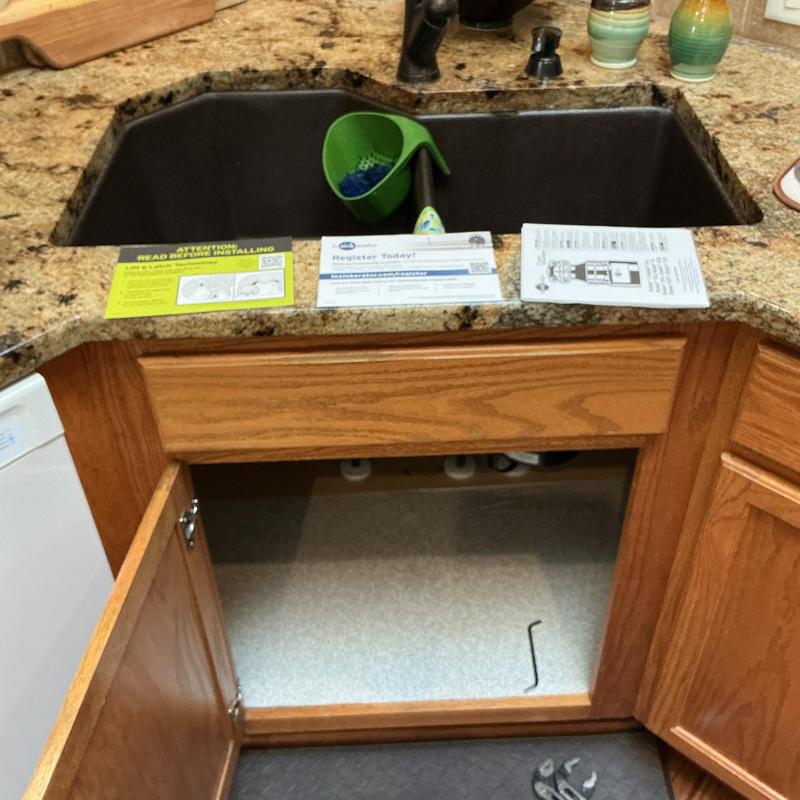Disposer removal under kitchen sink with manual and tools Disposer removal under kitchen sink with manual and tools
