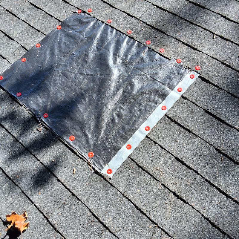 Roof penetration covered with secured tarp patch Roof penetration covered with secured tarp patch