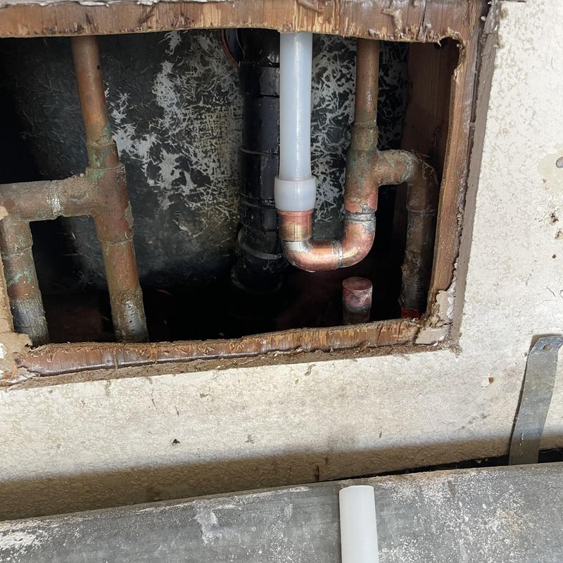PEX water line with copper fittings inside wall cavity