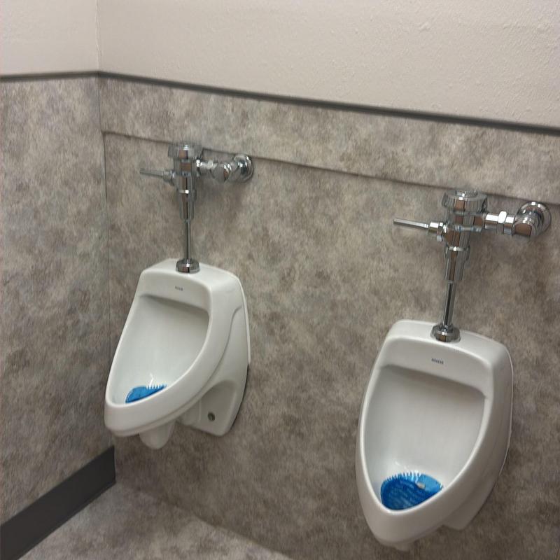 Urinal flush valve installation in commercial restroom