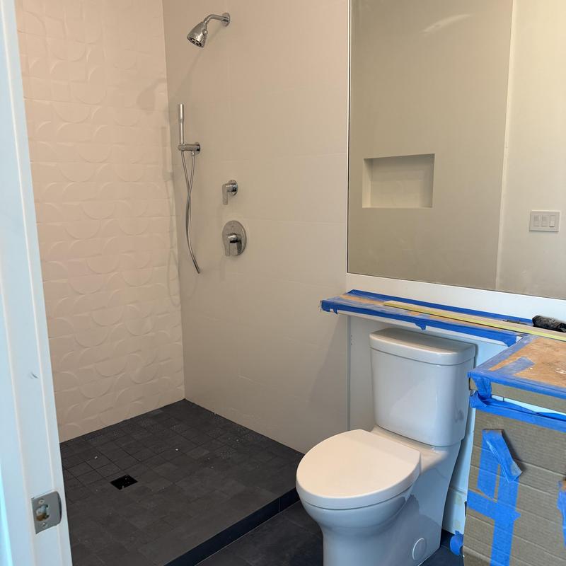 Toilet and shower head installation in bathroom remodel