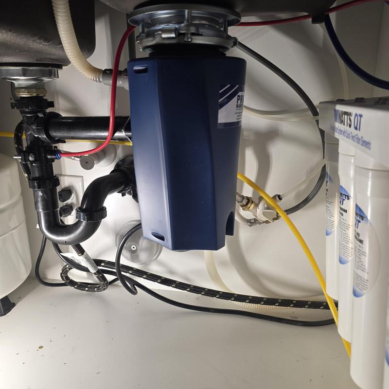Garbage disposal under kitchen sink with plumbing connections
