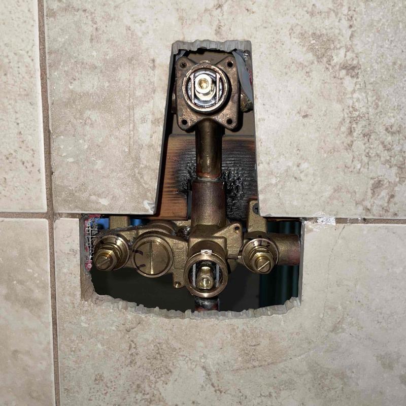 Shower valve assembly behind tile wall cutout