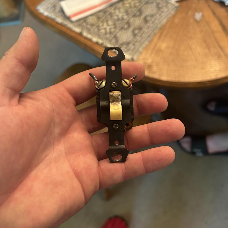 Old damaged furnace power switch in hand Old damaged furnace power switch in hand