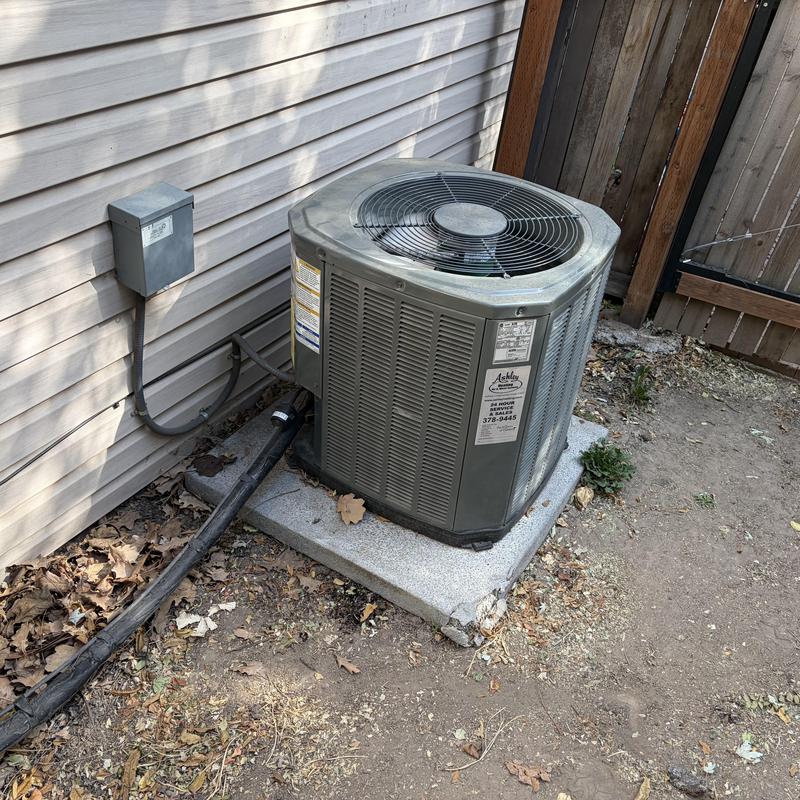 Outdoor AC unit on concrete pad near house siding Outdoor AC unit on concrete pad near house siding