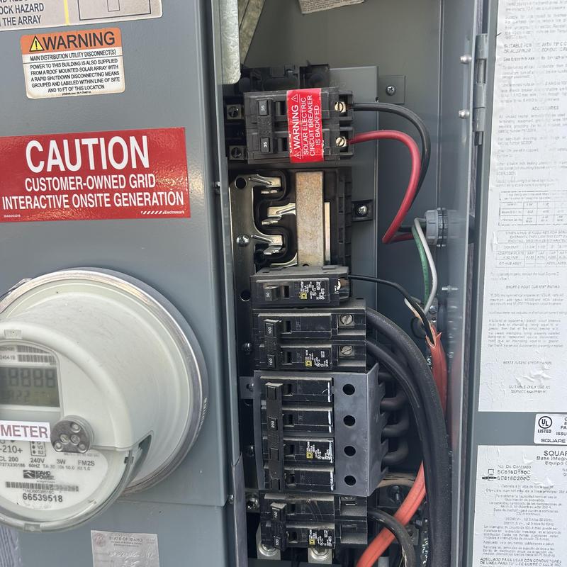 Electrical breaker panel with warning labels and meter Electrical breaker panel with warning labels and meter