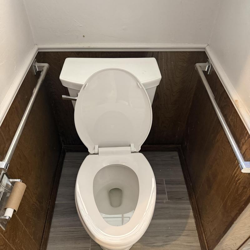 Toilet with open lid and tank in small bathroom Toilet with open lid and tank in small bathroom