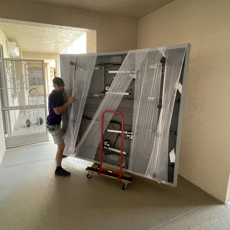 Foosball table being moved with dolly in hallway