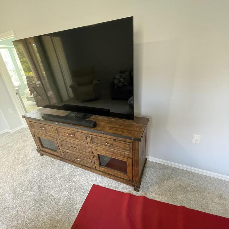 Flat-screen TV on wooden media console in living room