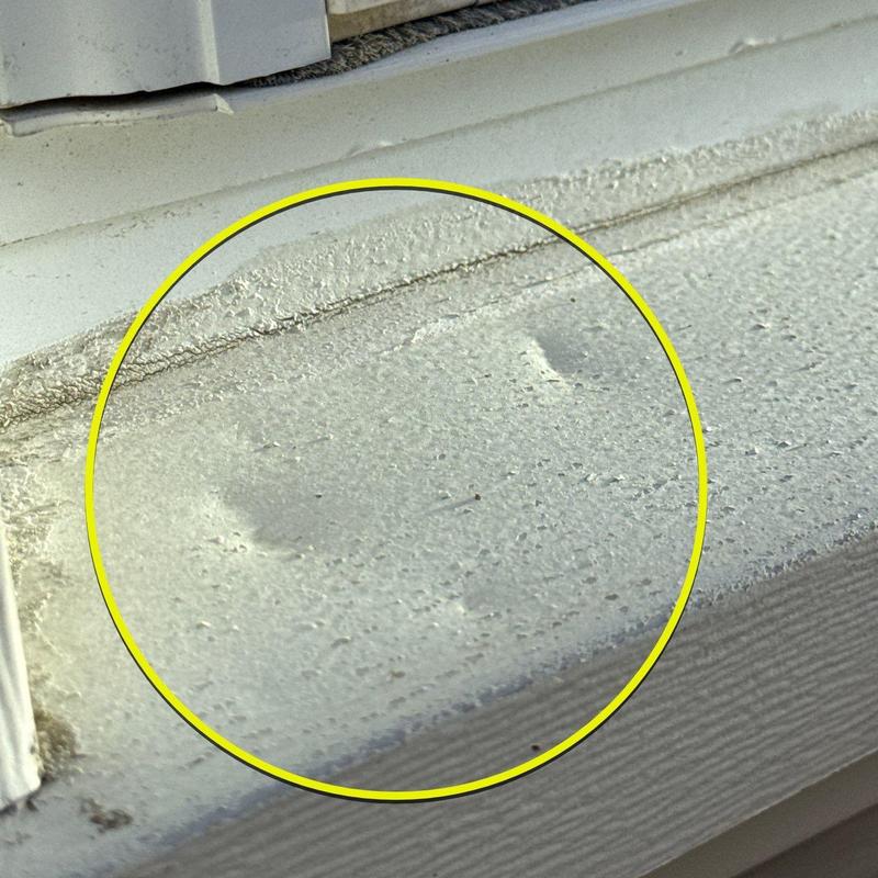 Window sill with hail damage dents and paint wear