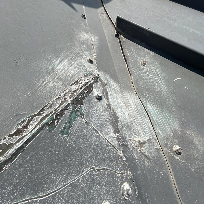 Metal roof panel with hail damage and corrosion