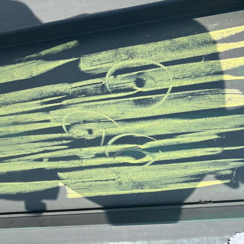 Metal commercial roof hail damage marked with yellow chalk