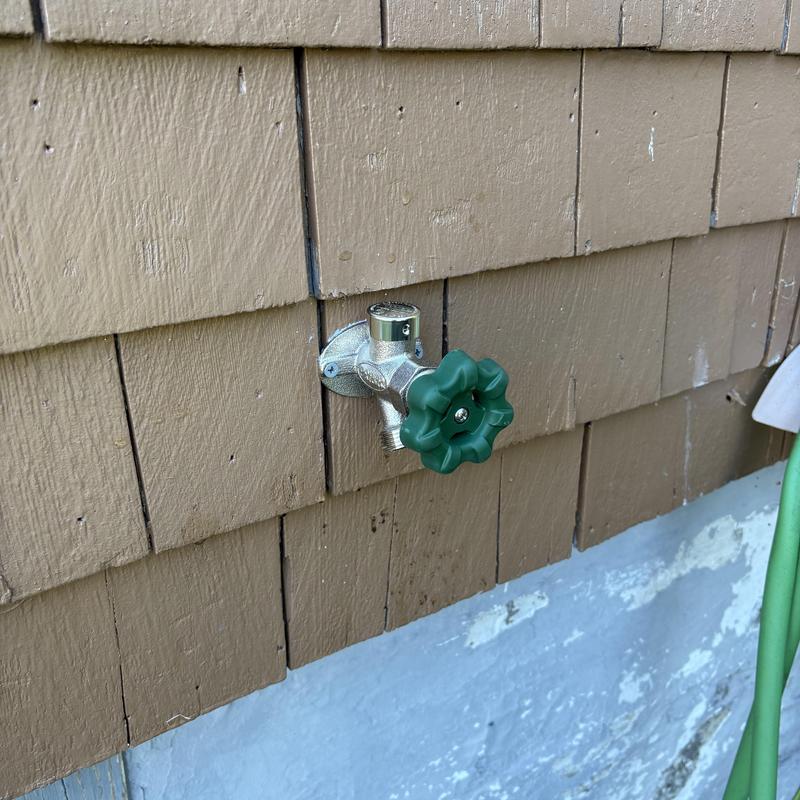 Frost-free outside faucet with green handle installed