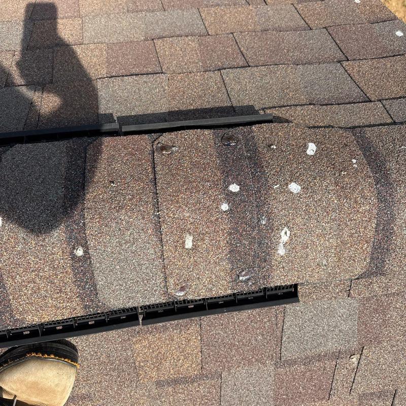 Asphalt roof shingles with visible hail damage spots
