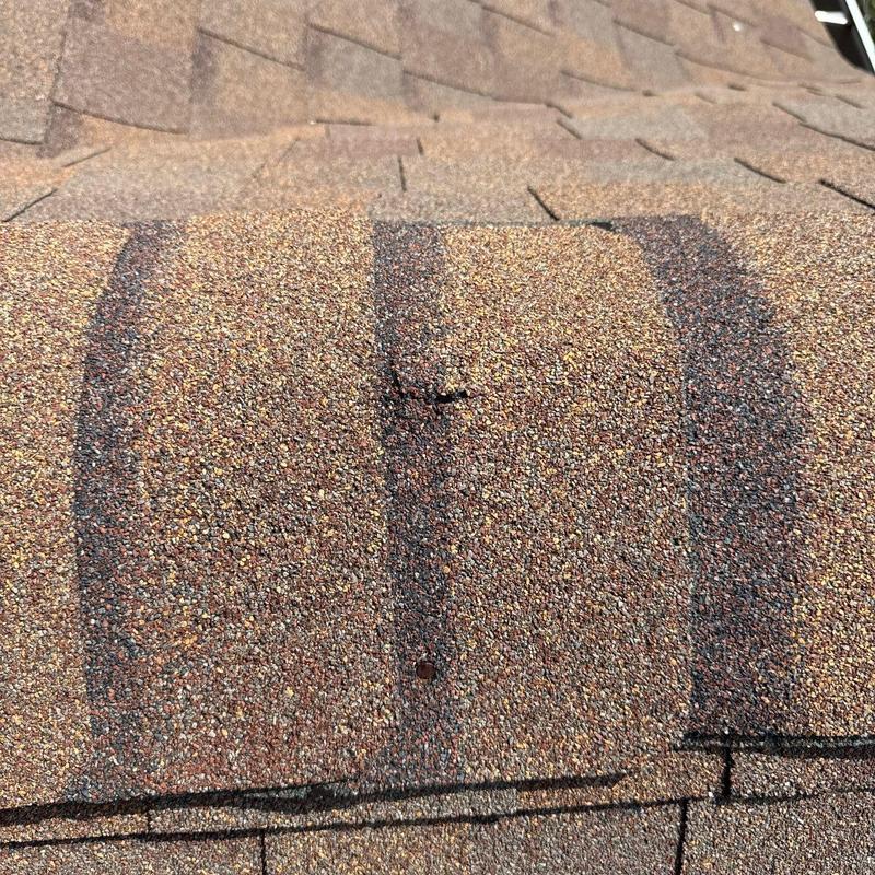 Asphalt roof shingles with hail damage close-up