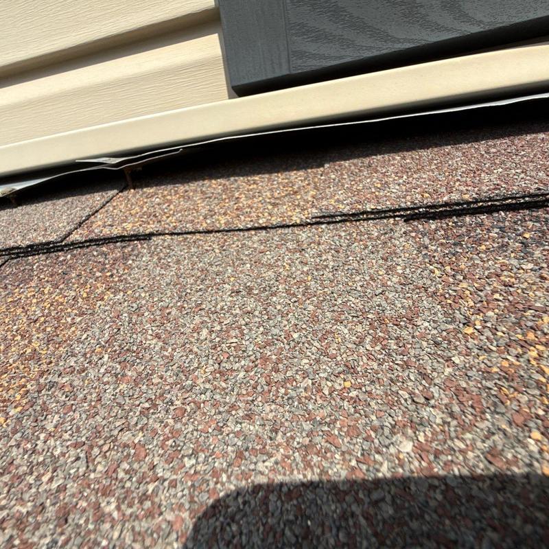 Roof shingles with hail damage near siding trim