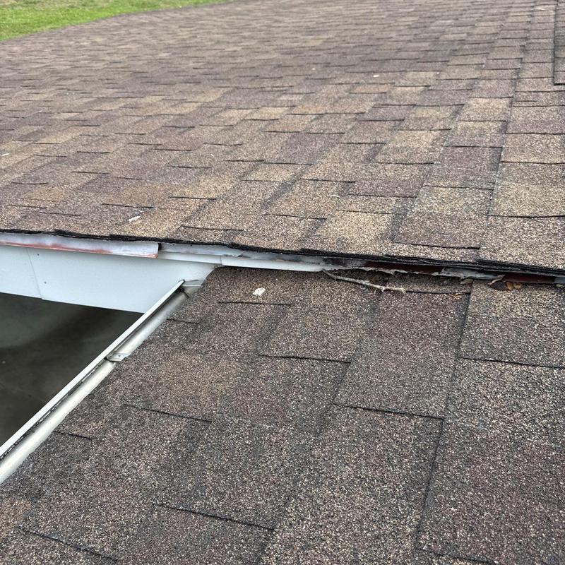 Asphalt shingle roof with damaged flashing and gap