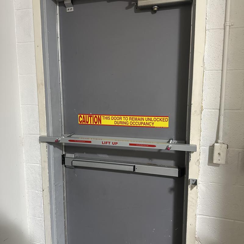 Exit security bar on gray commercial door interior Exit security bar on gray commercial door interior