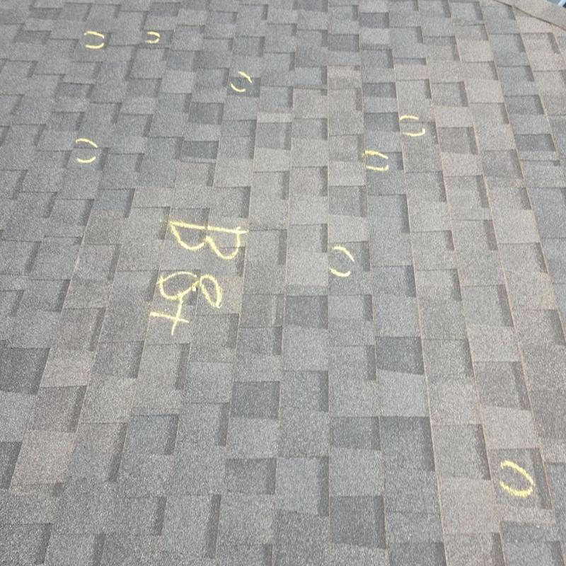 Roof shingles with hail damage marked in yellow
