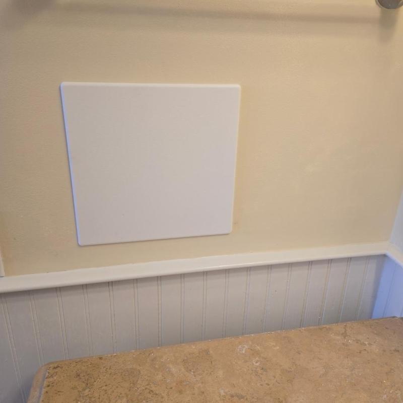 Shower valve access panel installed on bathroom wall
