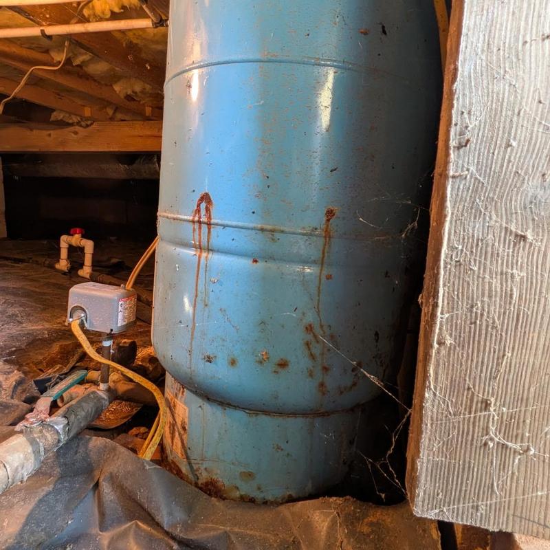 Blue well pressure tank with rust stains in crawlspace Blue well pressure tank with rust stains in crawlspace