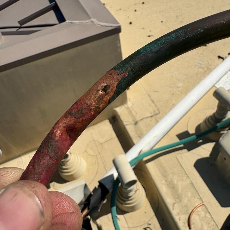 Copper liquid line showing corrosion and leak hole
