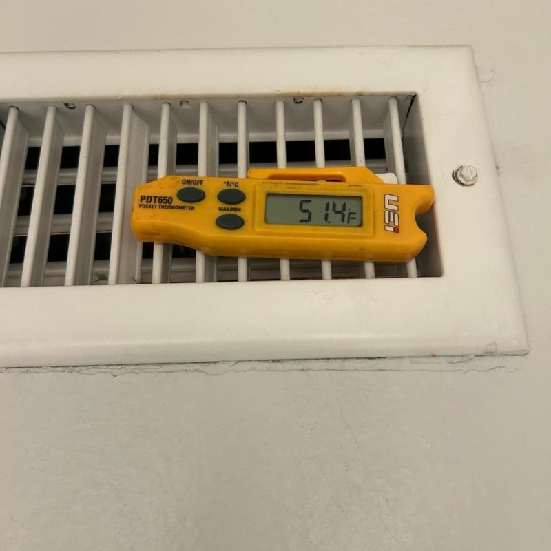 Air vent thermometer reading 51.4°F in HVAC system
