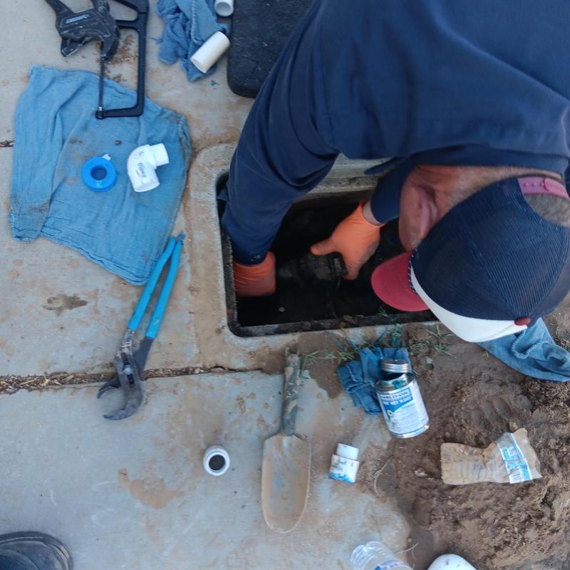 Water meter box with plumber repairing water line Water meter box with plumber repairing water line