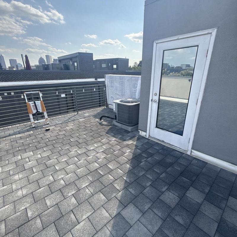 Rubber roof surface with door and HVAC unit on condo rooftop