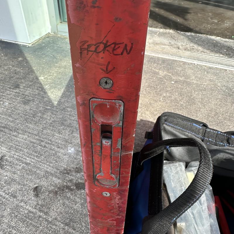 Flush bolt on red glass door marked broken Flush bolt on red glass door marked broken