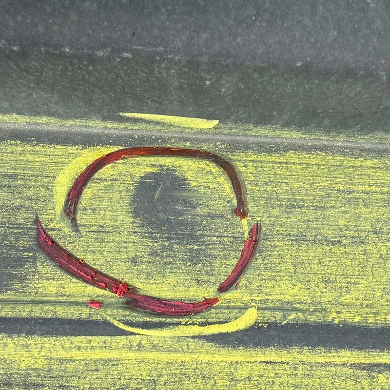Hail damage on asphalt roof shingle marked for repair