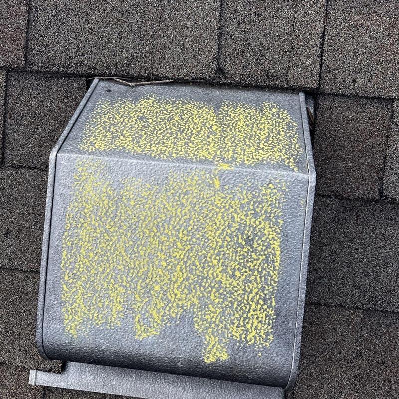 Metal roof vent with hail damage marked in yellow