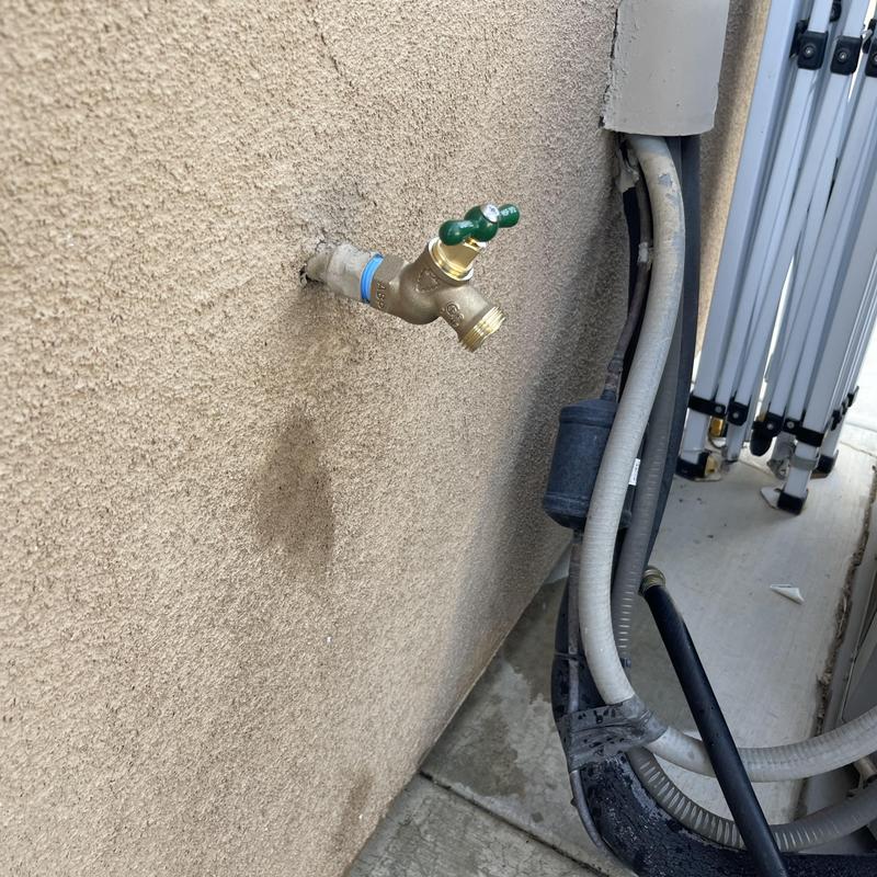 Threaded hose bib on exterior wall near HVAC unit