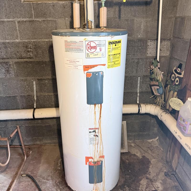 Water heater with rust stains and connected pipes
