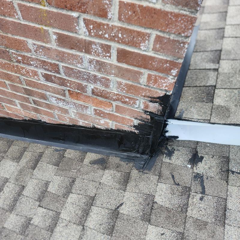Chimney flashing with temporary sealant on roof shingles Chimney flashing with temporary sealant on roof shingles