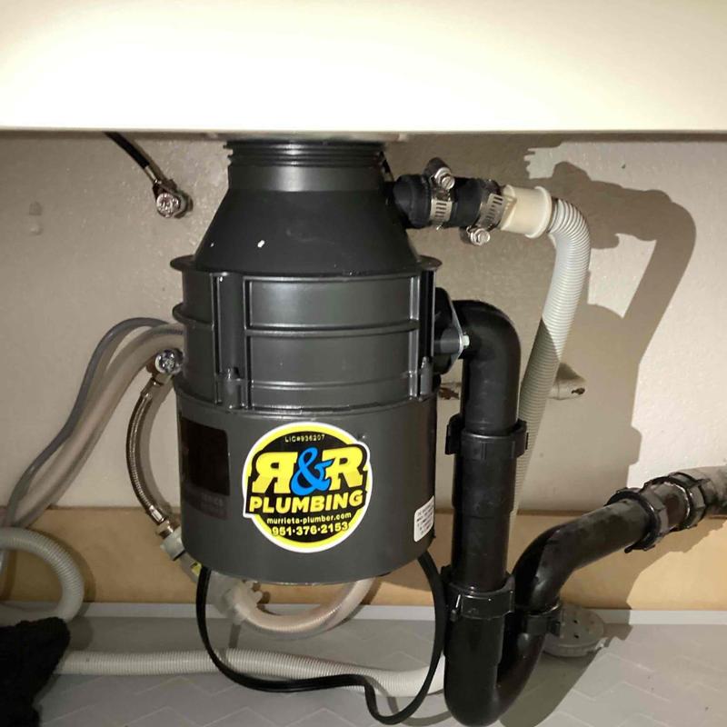 Garbage disposal unit with connected plumbing pipes