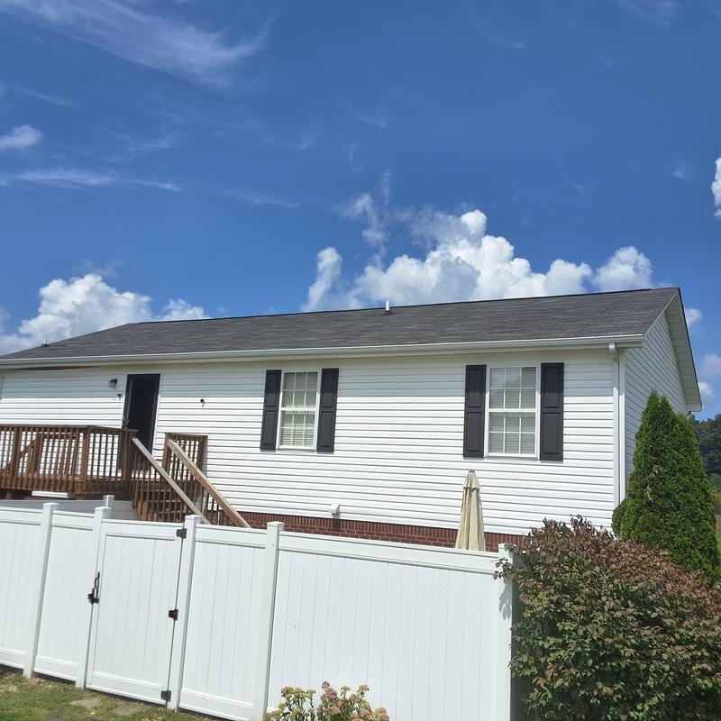 Asphalt shingle roof on single-story home under clear sky
