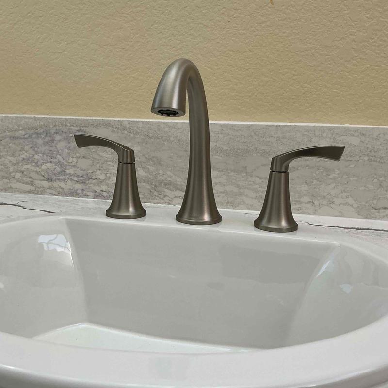 Bathroom faucet with brushed nickel finish on sink