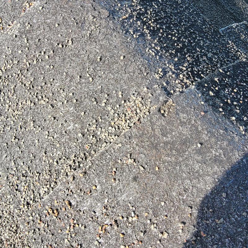 Roof shingles close-up with granule texture and shadows Roof shingles close-up with granule texture and shadows