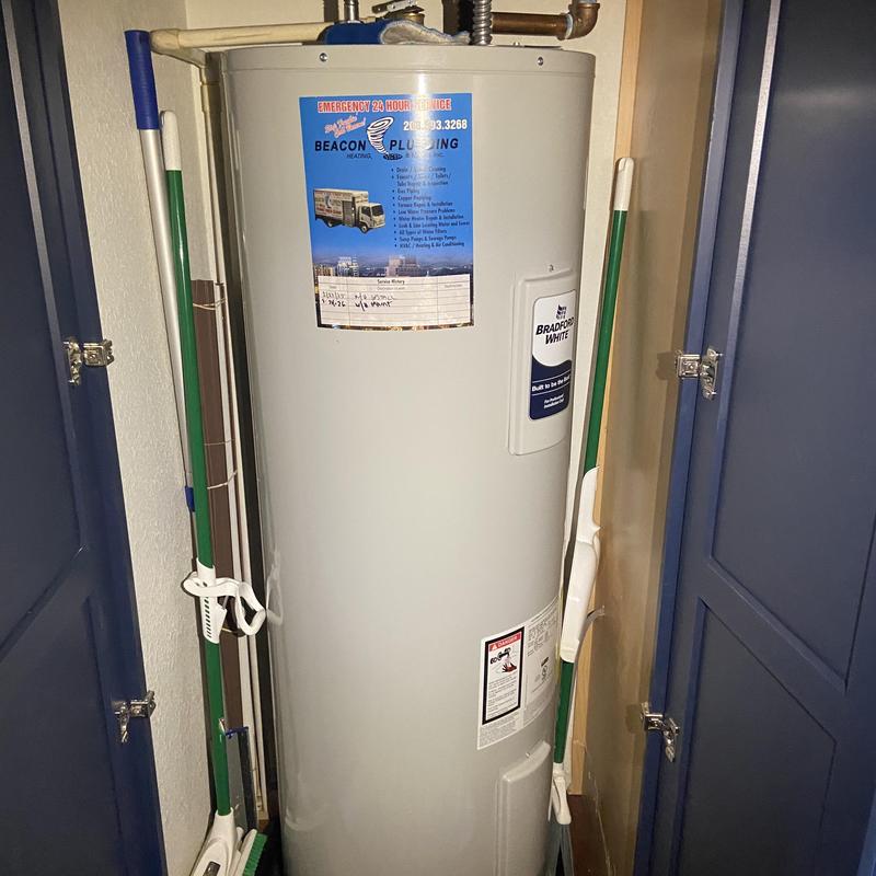 Water heater tank with Beacon Plumbing service label